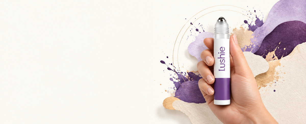 Hair-growth roll-on held against colorful abstract artwork